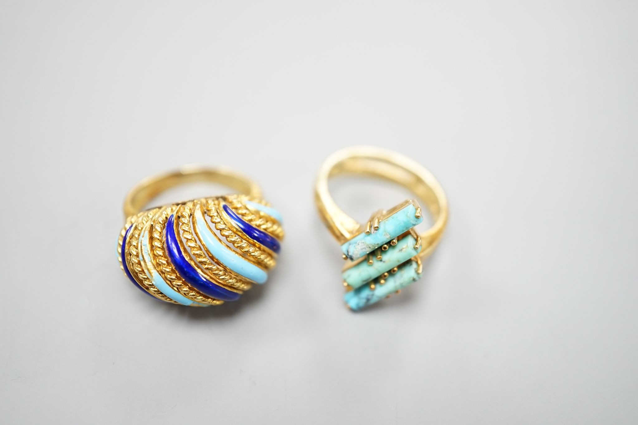 An Italian yellow metal and tow colour enamel set dress ring, size G/H and a yellow metal and three stone turquoise set modernist ring, gross 16 grams.